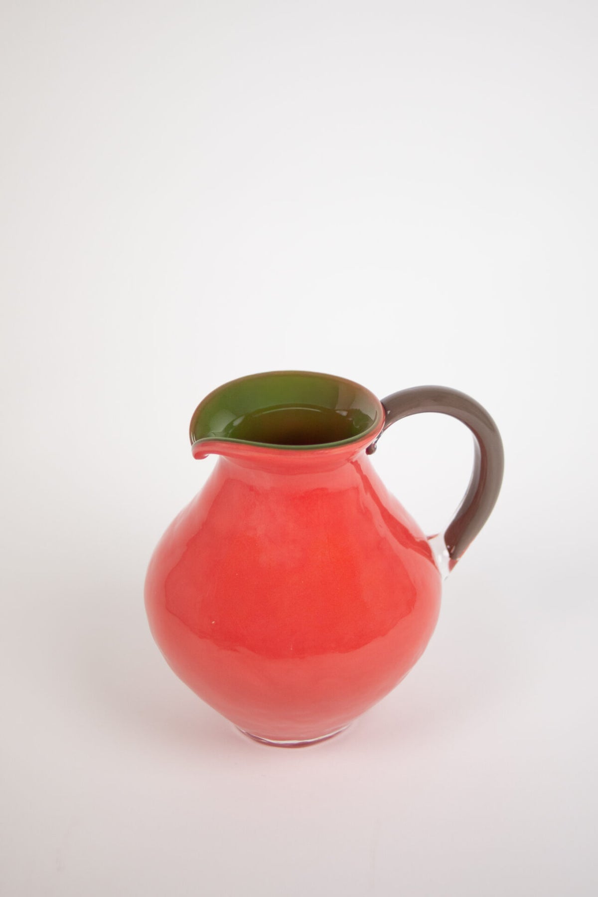 Kiko coral pink glass jug with a green inside and brown handle by Olsson & Jensen