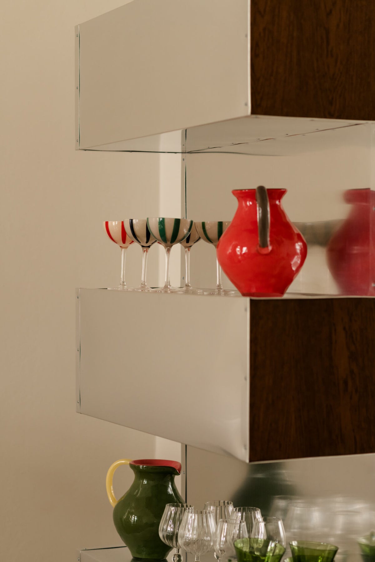 Kiko green and coral jugs by Olsson & Jensen on open shelving