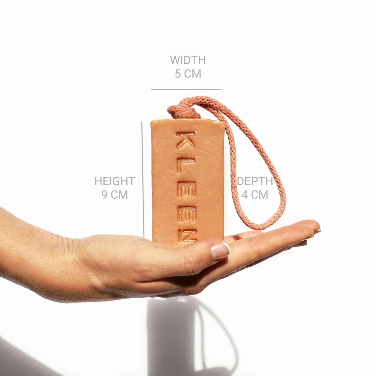 Hand holding the KLEEN Good Vibrations soap bar with dimensions marked to show its size