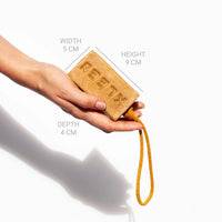 Hand holding the KLEEN Yellow Mellow soap bar with dimensions marked to show its size