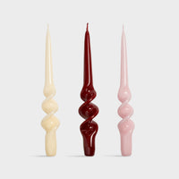  set of three &klevering candle alpha spiral tapers in cream red and pink
