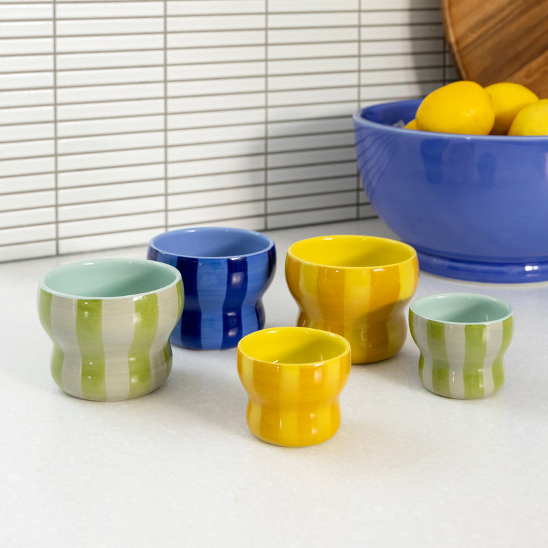 colourful &klevering circus collection mugs in assorted sizes grouped on countertop
