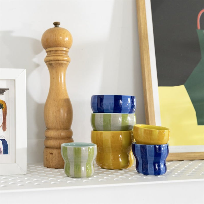 mix of &klevering circus cups stacked on a shelf with small green espresso cup in front
