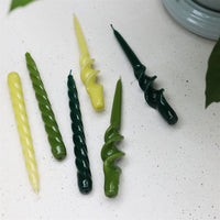 glossy green spiral and twisted tapers by &k shown in a range of tones

