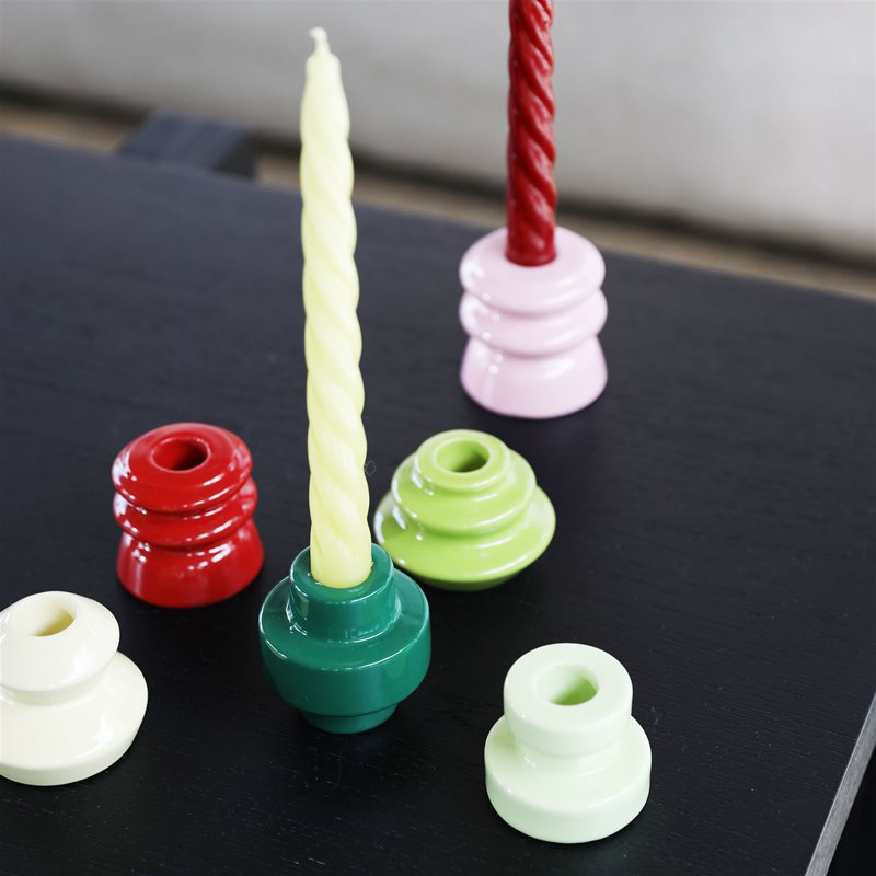 mix-and-match &klevering candle holders with pale yellow-green spiral taper on black table
