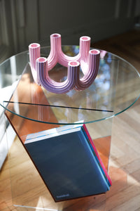 sculptural pink multi-arm candle holder by &K seen from above on glass table
