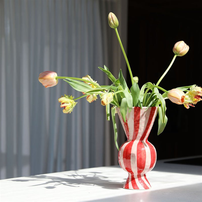 &k rhombic red striped vase filled with tulips in soft daylight

