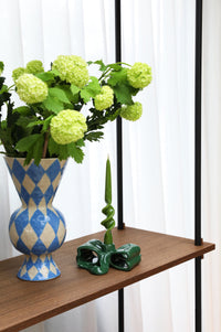 glossy twisted dinner candle by &klevering adding a sculptural note to a modern shelf
