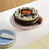 chocolate layer cake topped with berries on &klevering whip pink cake stand with matching plates
