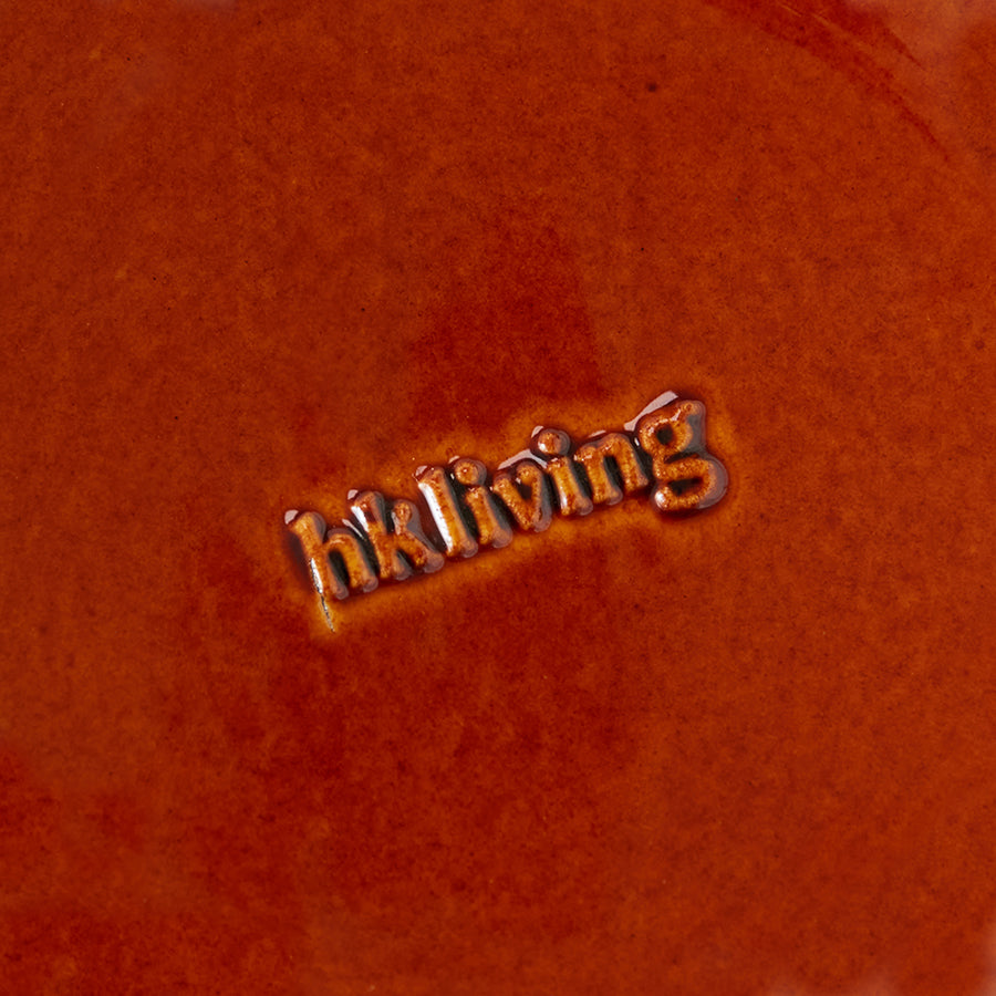 Close-up of a textured underside of plate with 'hkliving' embossed.