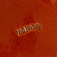 Close-up of a textured underside of plate with 'hkliving' embossed.