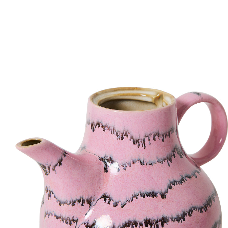 Pink ceramic teapot with black abstract patterns on a white background