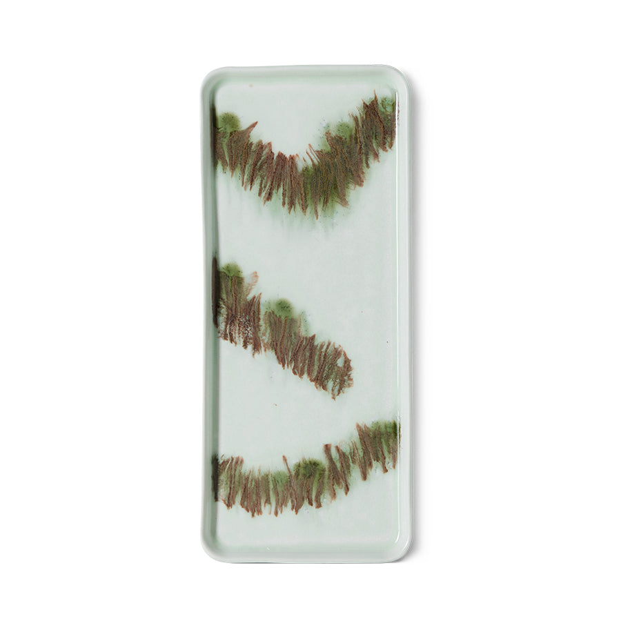 Overhead view of the HKLIVING Tide cake tray in green stoneware on a plain white background, showing its flowing brushstroke glaze pattern
