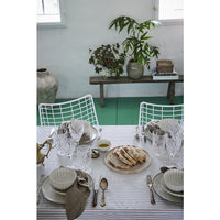 Ellia beige marble tray holding bread on a laid dining table with striped tablecloth