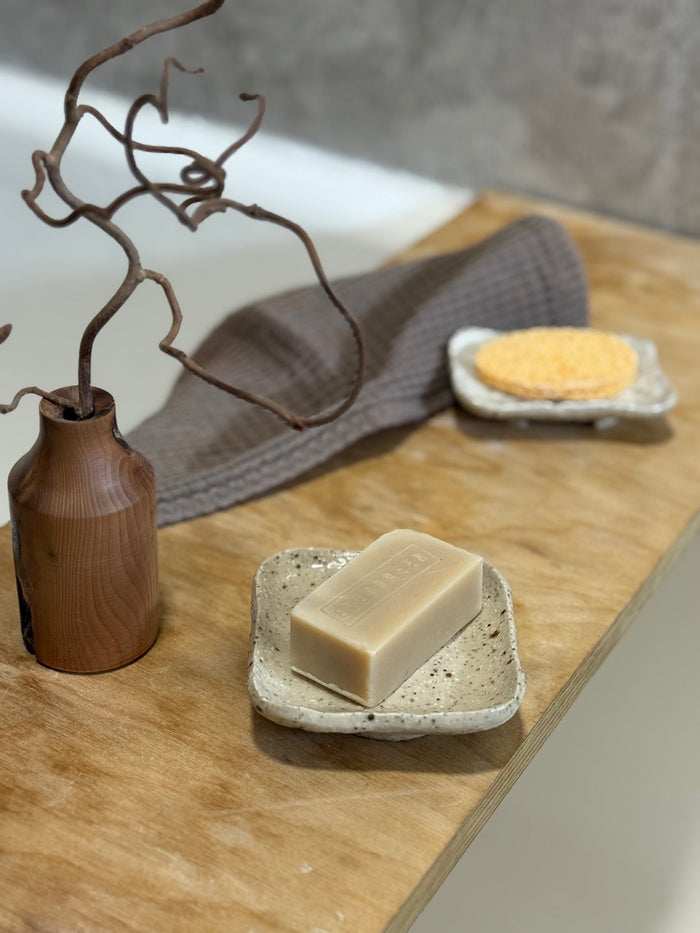 Bathroom scene with handmade ceramic soap dish and natural soap bar