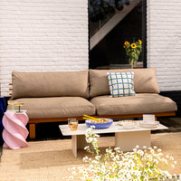 lifestyle shot of beige sofa with a set up including sald ready to be served with striped &Klevering salad servers