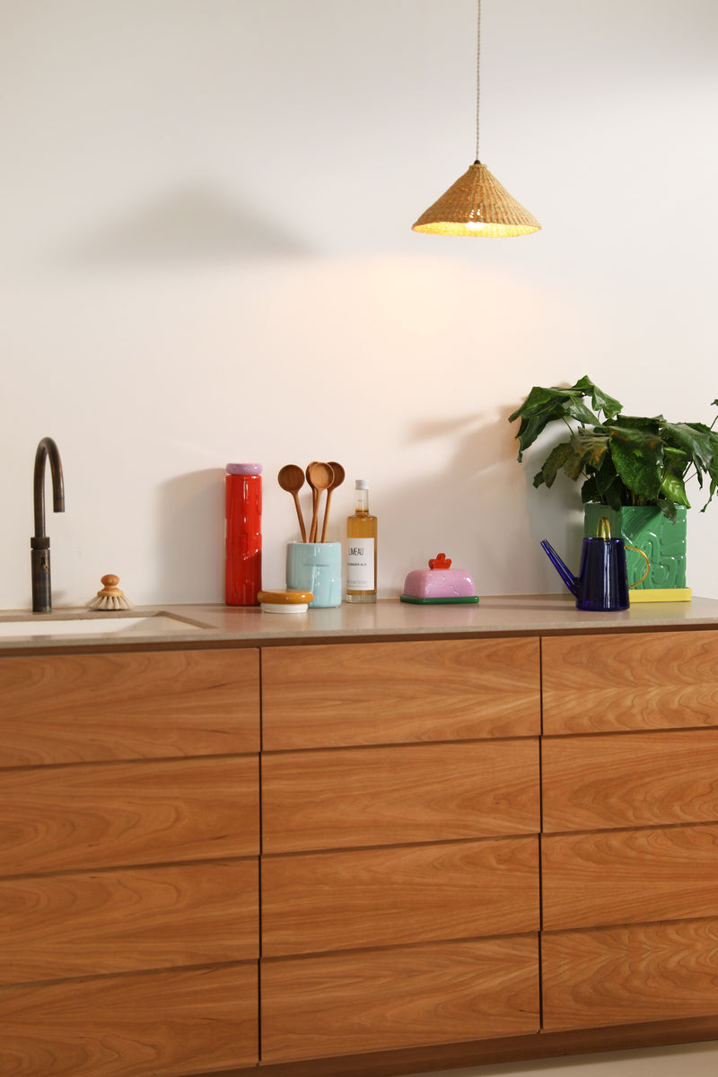 Sketch Lilac butter dish styled on a warm wood worktop for a colourful, lived-in kitchen feel.
