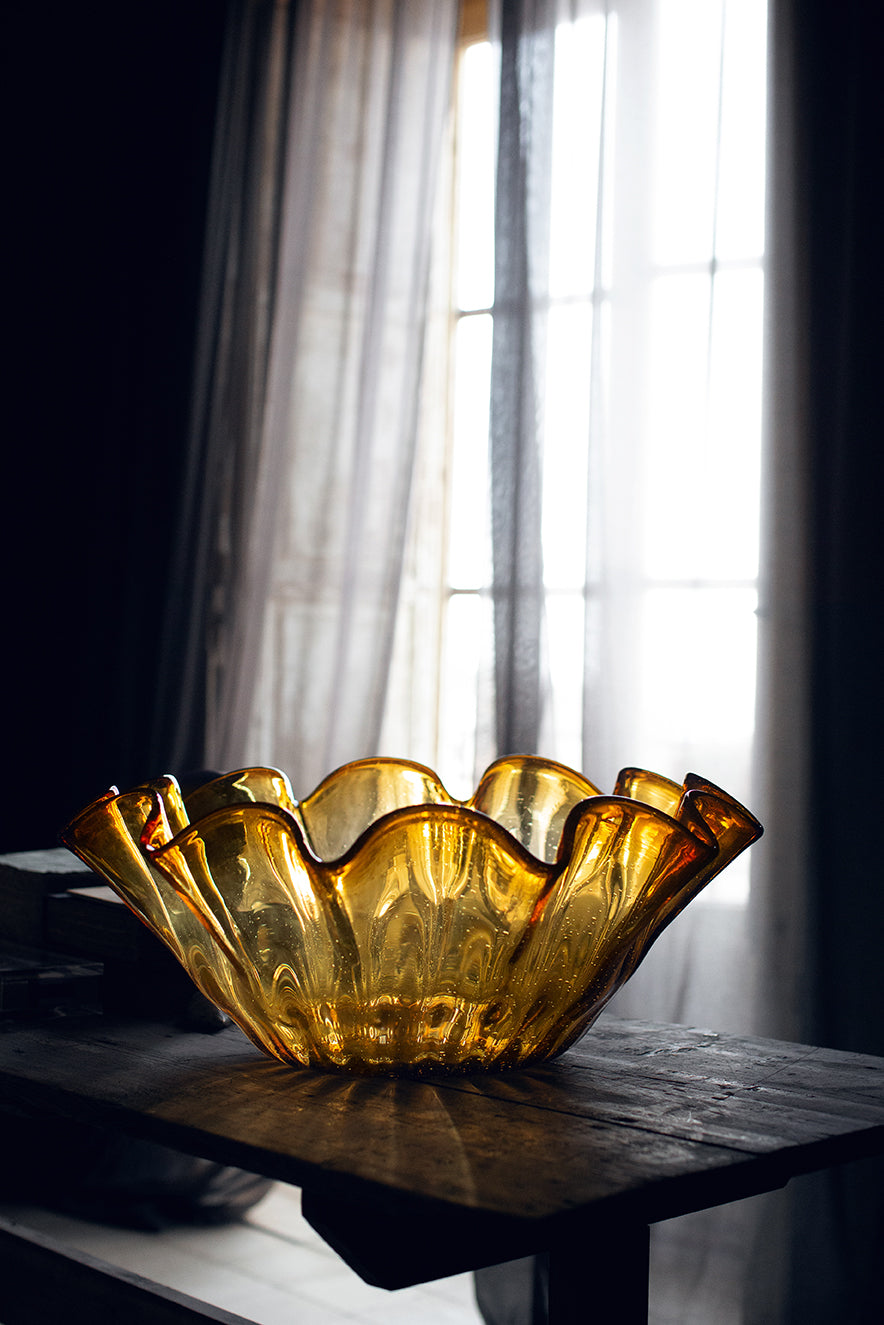 Large amber glass Ciotola Increspato bowl by hkliving displayed as a dramatic centrepiece