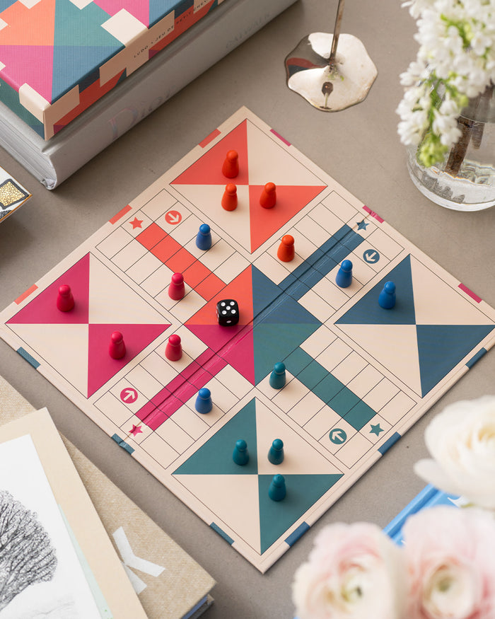 Open Ludo board in play with colourful pieces