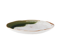 side view of white and green stoneware dinner plate showing curved edge
