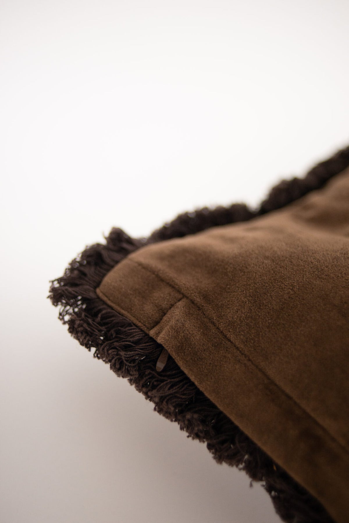 Plain brown velvet reverse and fringe of the Maribel cushion by Olsson & Jensen