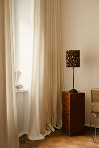 Maribel lamp shade by Olsson & Jensen on a floor lamp beside linen curtains