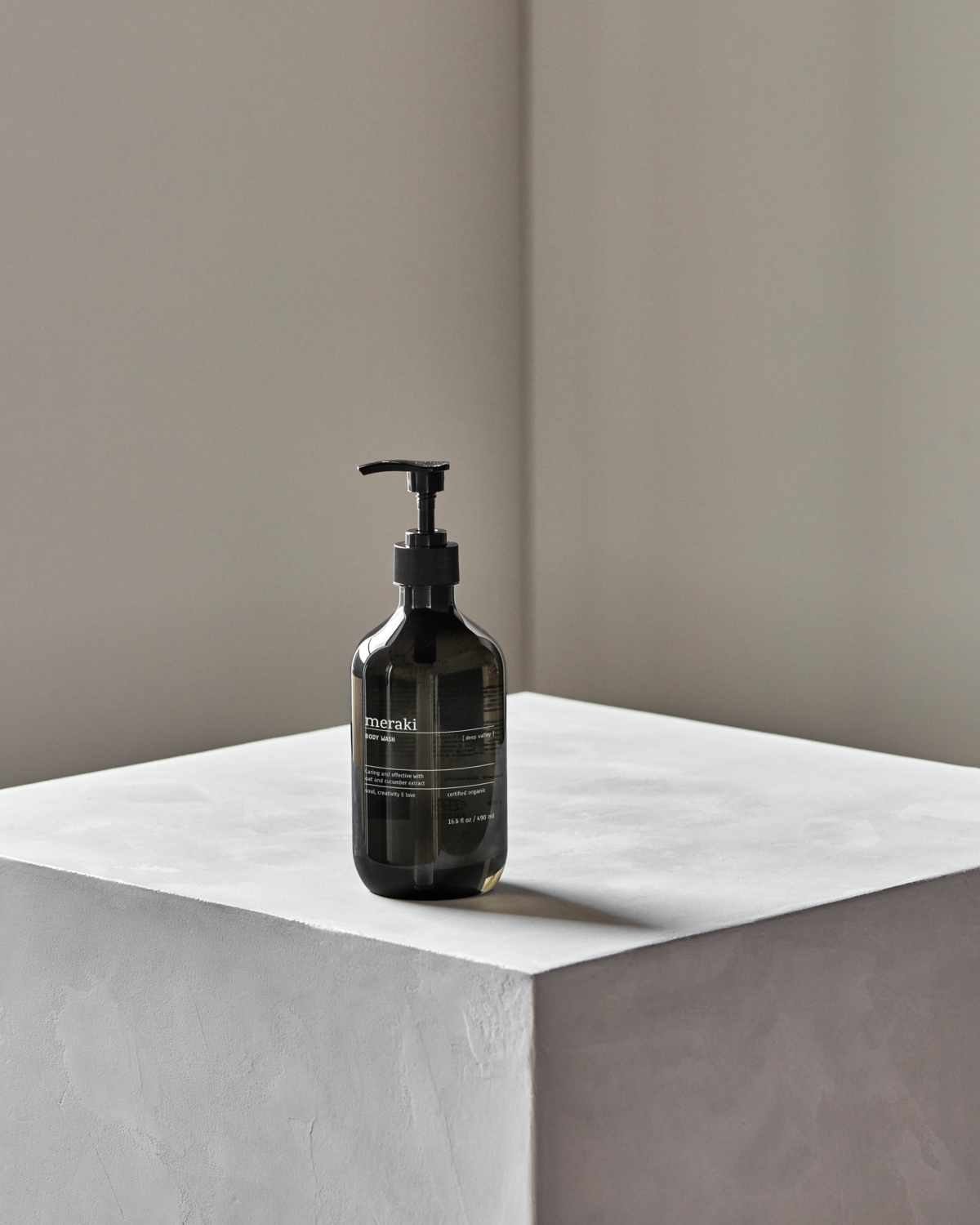 Meraki Body Wash Deep Valley 490 ml on concrete plinth – minimalist lifestyle shot.