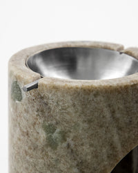 Close-up of the silver bowl and natural marble veining on the Meraki oil burner