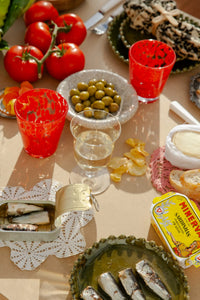 Milano red glass by Olsson & Jensen on a summer table with tomatoes, olives and tapas