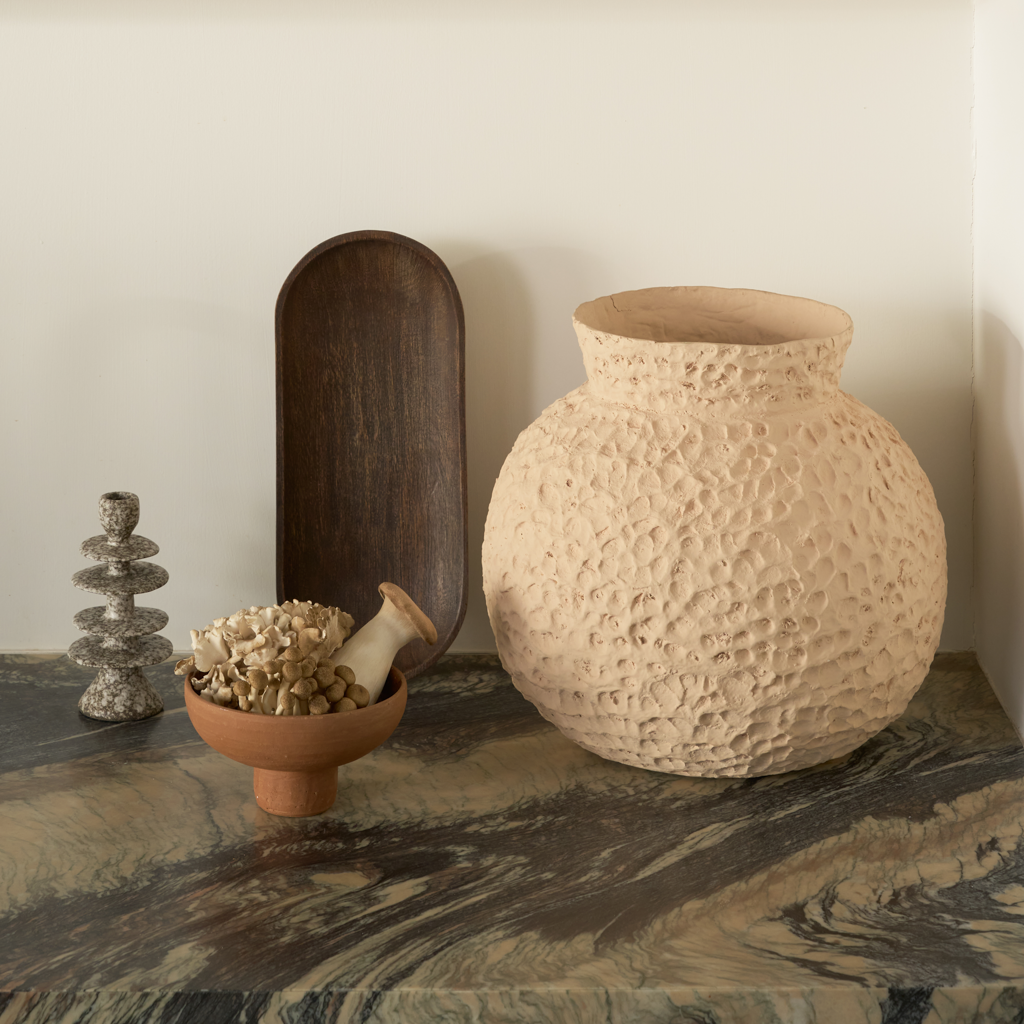 Milo candle holder styled beside a textured round vase and a bowl on a marble surface