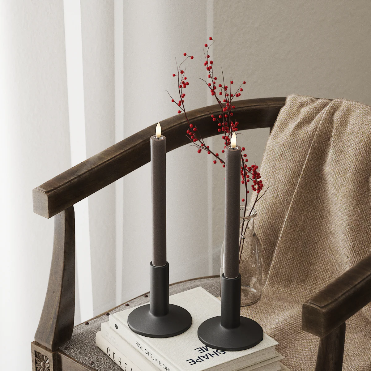 Mocha LED dinner candles on a wooden chair with red berries and a soft throw, adding cosy seasonal light to a corner.
