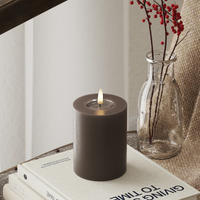 realistic mocha LED candle glowing softly in a cosy winter interior
