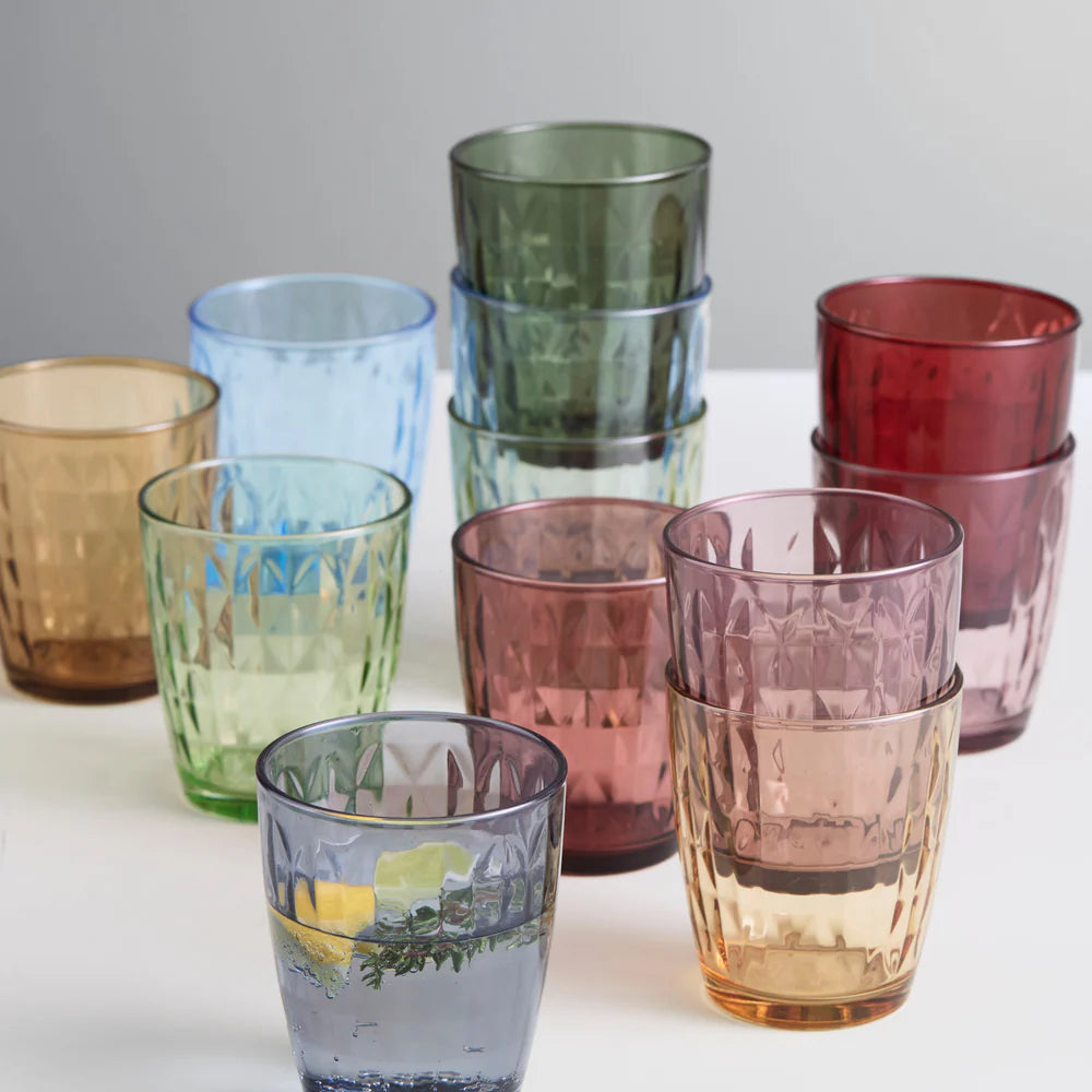 Set of multicolored Aida glass tumblers on a white surface with a light gray background