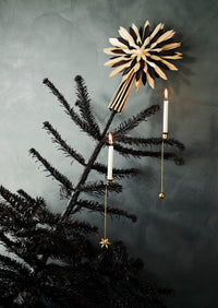 brass christmas tree candle holders clipped onto branches with lit white candles
