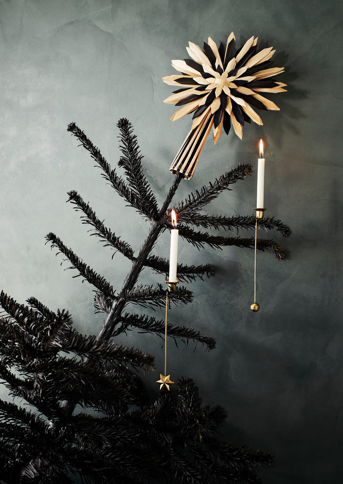 brass christmas tree candle holders clipped onto branches with lit white candles
