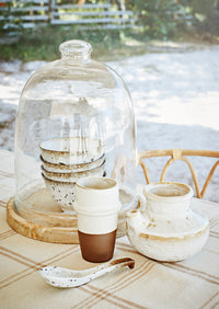 small reactive glaze stoneware bowl filled with fresh herbs on woven placemat
