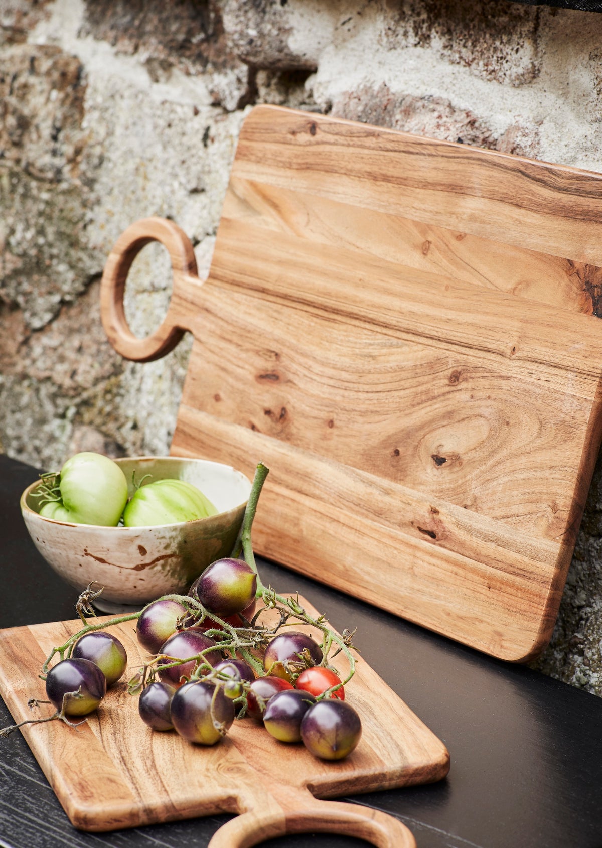 reactive glaze stoneware bowl in white and green on an outdoor table with fresh produce
