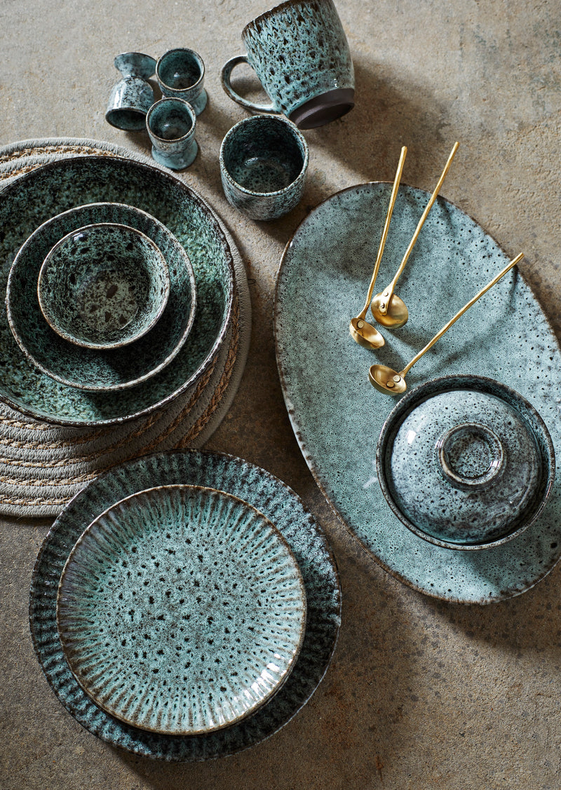 petrol green reactive glaze tableware collection including plates and bowls
