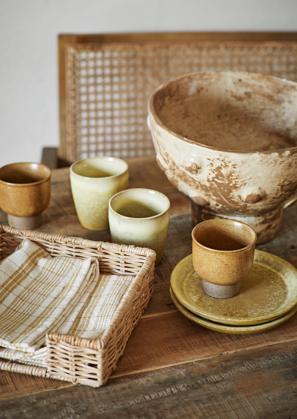 assorted artisan stoneware cups and mugs in a creative Nordic table setting
