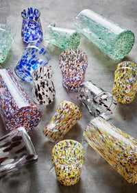 assorted handmade glass jugs and tumblers with colourful speckled patterns
