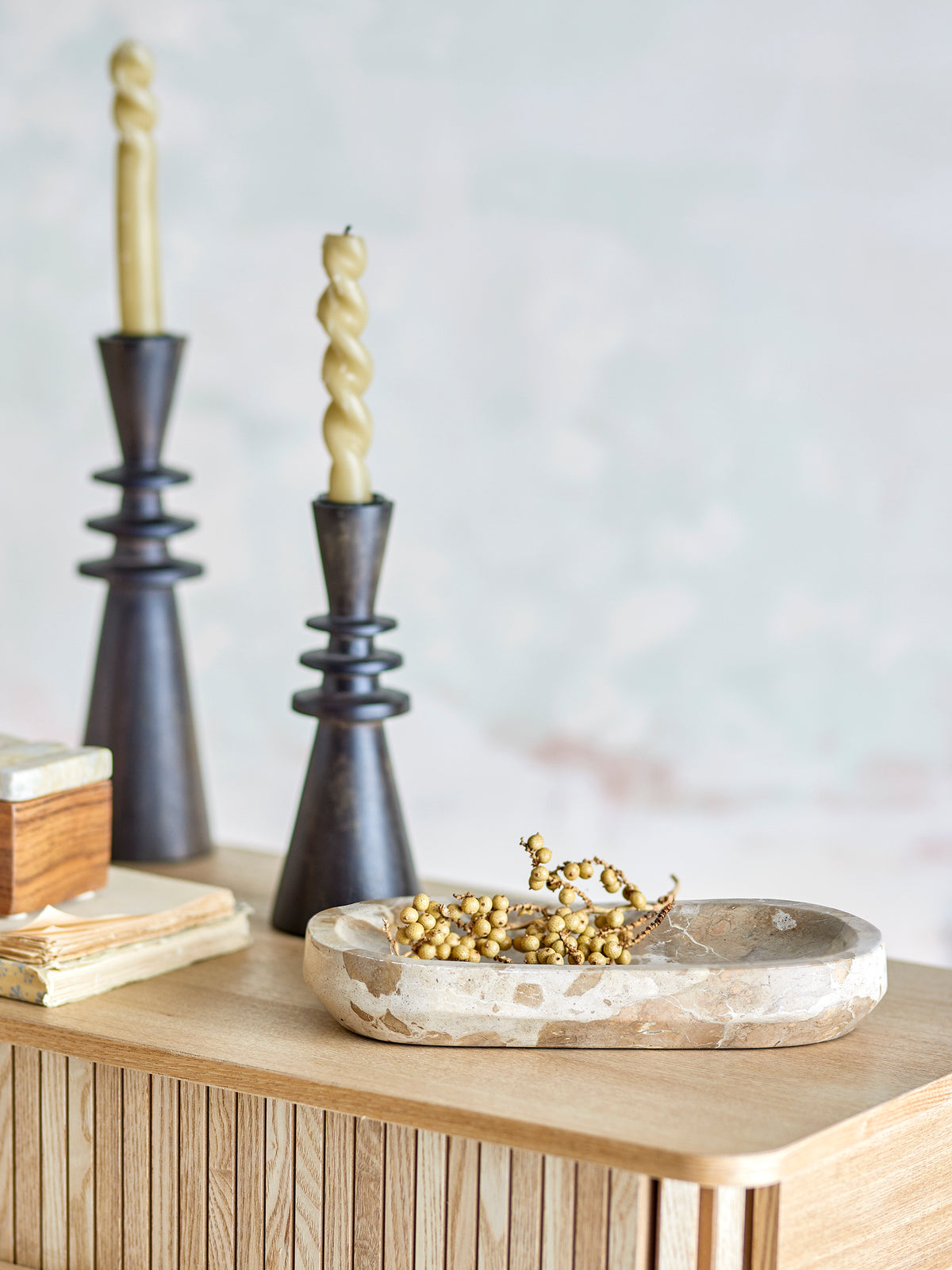 Neutral marble tray styled with candles and gold accents on oak surface