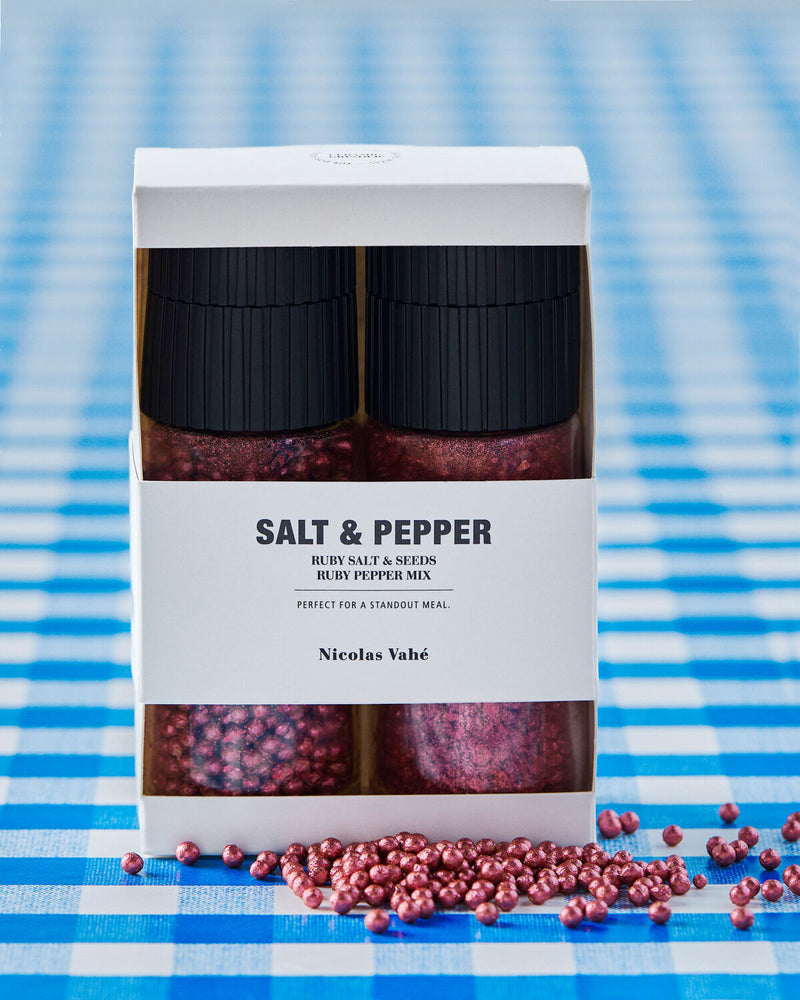 Nicolas Vahé ruby salt and pepper gift box on a blue gingham tablecloth scattered with ruby peppercorns
