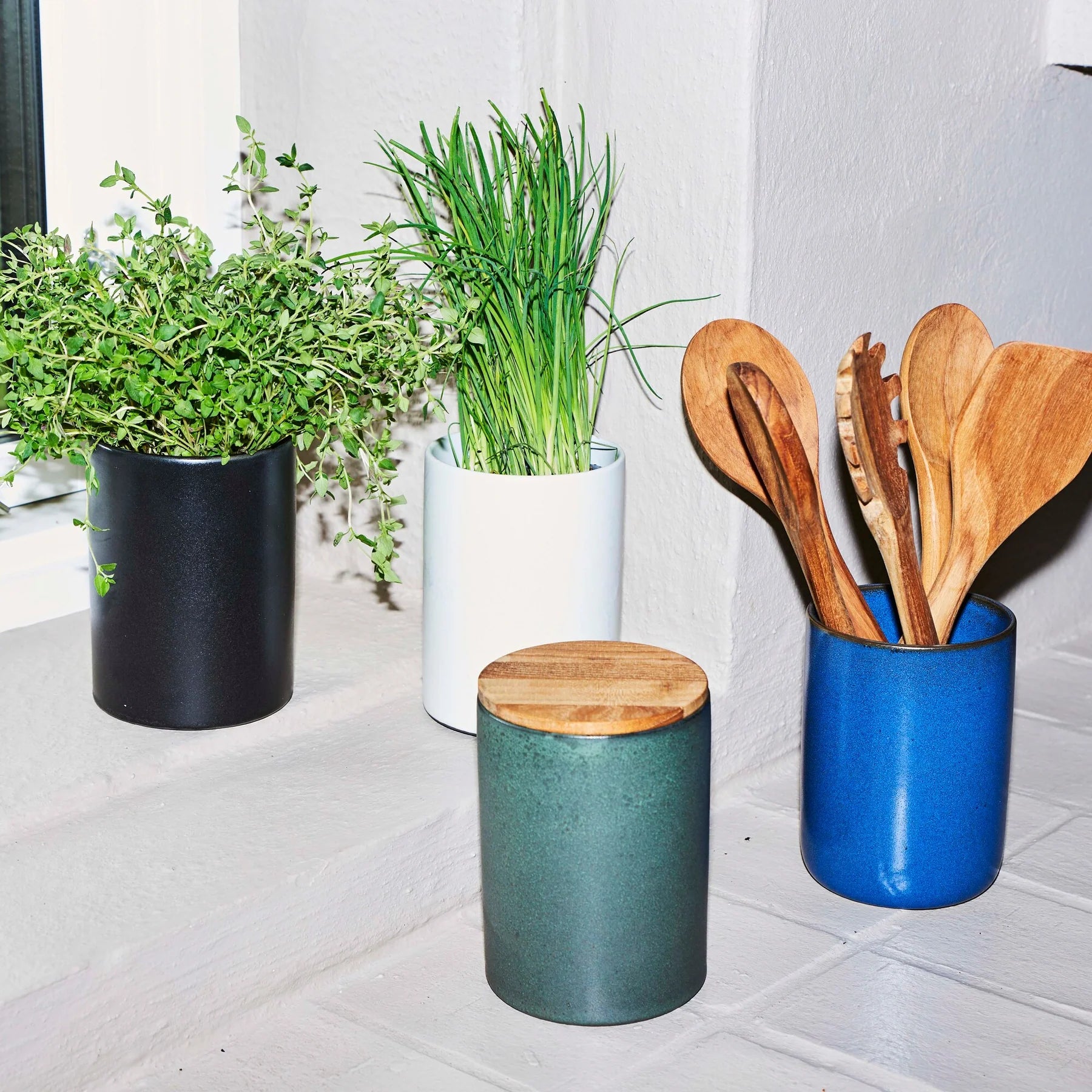 northern green stoneware canister with teak lid by aida in a styled kitchen setting