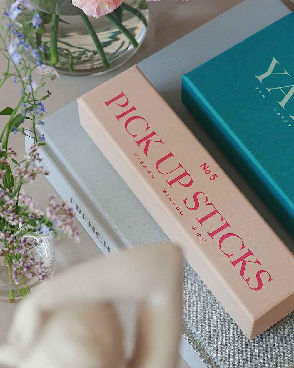 Pick Up Sticks box styled on coffee table with flowers and books