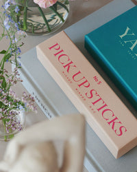 Pick Up Sticks box styled on coffee table with flowers and books