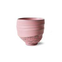 Handleless pink stoneware cup with gentle throwing rings and unique variations.
