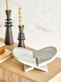 Marble book stand beside gold sink and ceramic pitcher in kitchen scene