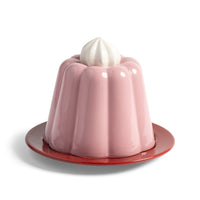 Pudding cloche in pink stoneware with whipped-cream handle on red plate by &Klevering