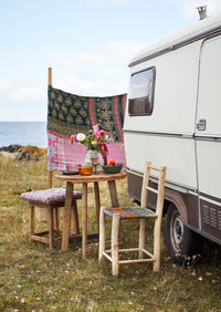 purple wine glass styled on rustic outdoor table with caravan
