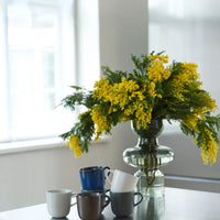RAW northern green coffee cups by aida styled on a bright table with spring flowers
